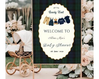 May include: A rectangular welcome sign with a dark green and navy blue plaid background. The center features a cream-colored oval with gold trim, displaying the text "WE CAN Bearly Wait", "WELCOME TO", "Alma Mae's", "Baby Shower", and "08 / June / 2030".
