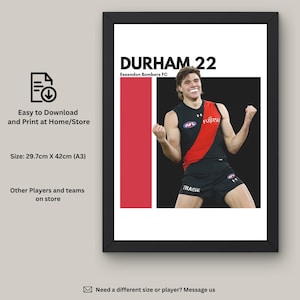 May include: Framed print of an athlete in a black and red uniform, with the text "DURHAM 22" and "Essendon Bombers FC". The print measures 29.7cm x 42cm (A3).