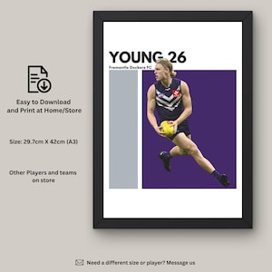 Puede incluir: Un póster imprimible con una foto del jugador de fútbol australiano, Young, vistiendo una camiseta morada y blanca con el número 26. El póster se titula "Young 26" con el texto "Fremantle Dockers FC" debajo. El póster está enmarcado en negro y tiene un fondo blanco.