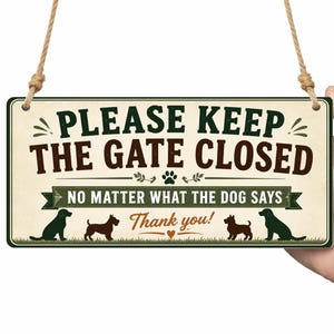 May include: A rectangular sign with the text "PLEASE KEEP THE GATE CLOSED" and "NO MATTER WHAT THE DOG SAYS". The sign features dog silhouettes and is held by a hand.