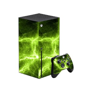Puede incluir: Una consola Xbox Series X y un mando con un diseño de relámpagos verdes. La consola es una torre rectangular negra. El mando es negro con botones verdes y un patrón de relámpagos a juego.
