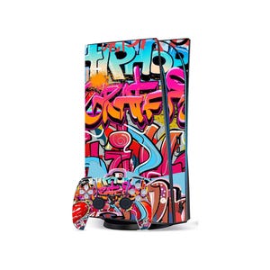 May include: A games console and controller set with a colourful graffiti design. The console is black with a graffiti wrap, and the controller has a matching design. The graffiti art includes various colours and abstract shapes, creating a bold aesthetic.