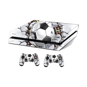 Op de afbeelding: Een witte Sony PS4-console en twee bijpassende controllers. De console en controllers hebben een voetbalontwerp dat door een gebarsten muur breekt. Het ontwerp bevat zwart, wit en grijstinten. De console heeft de tekst "PS4".
