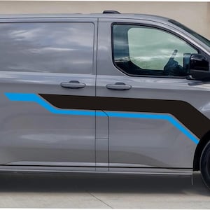 Puede incluir: Una furgoneta gris con ruedas negras y un diseño gráfico negro y azul en el lateral. La furgoneta tiene cristales tintados y un retrovisor lateral negro. El gráfico es una serie de líneas anguladas.