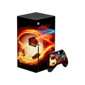 May include: Black gaming console and controller featuring a soccer ball and flame design. The console is rectangular with a textured top. The controller has buttons and joysticks.