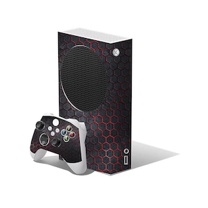 May include: A black and red gaming console and controller set. The console has a honeycomb pattern with red accents. The controller has a matching design with white accents and coloured buttons. The set is designed for gaming.