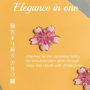 May include: A close-up of a yellow card with the text "Elegance in one" and Japanese characters. A pink and white flower-shaped object is in the center. The text "Inspired by the Japanese haiku, let snowboarders glide through snow and clouds with divine poise" is also visible.