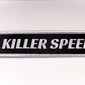 May include: Black and white key chain with a silver ring and the text "KILLER SPEED" in white.