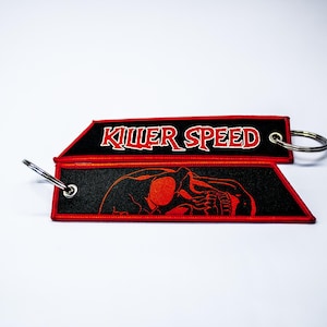 May include: Black and red key chain with a skull graphic and the text "Killer Speed".