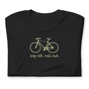 May include: Black t-shirt with a light beige bicycle outline and the text "log off. roll out." beneath the graphic. The t-shirt is folded.
