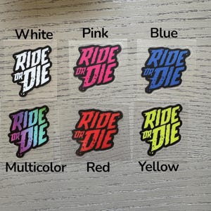 May include: A collection of six iron-on patches with the phrase "Ride or Die" in a stylized font. The patches come in white, pink, blue, multicolor, red, and yellow, each with a black outline. The colors are labeled below each patch.