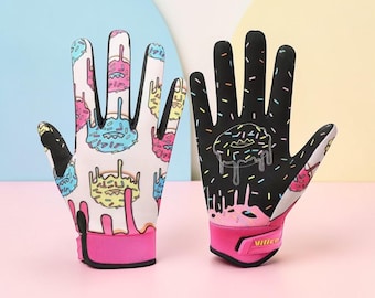 May include: A pair of athletic gloves featuring a donut print. The left glove is white with colorful donut graphics and pink drips. The right glove is black with a single donut graphic, colorful sprinkles, and a pink wrist strap with the text Vilico.