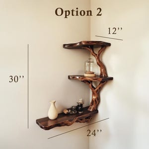 May include: A three-tiered corner shelf made from natural wood branches, with a rustic, tree-like design. The shelf is 30 inches tall, 24 inches wide, and 12 inches deep. Option 2.