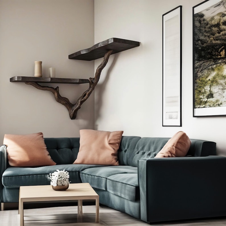 May include: A dark green sectional sofa with two light pink cushions. The sofa is positioned in a corner of a room with a wooden branch shelf and two framed pictures on the wall.