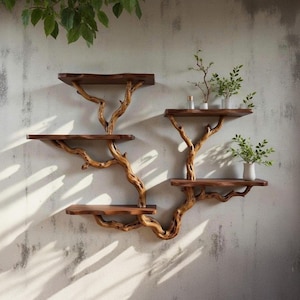 Könnte beinhalten: Handgefertigtes Wandregal aus Holz mit einem Astdesign. Die Regale sind in einem satten Braunton gehalten, und die Äste haben einen helleren, natürlichen Holzton. Das Regal ist mit kleinen Pflanzen in weißen Vasen dekoriert.