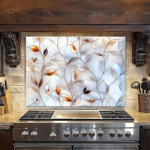 May include: A stainless steel stove with a glass backsplash featuring a floral design with brown and white leaves and flowers.