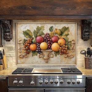 May include: A kitchen backsplash features a relief of a still life with grapes, apples, and oranges. The artwork is framed and set above a stainless steel gas range. The kitchen has dark wood cabinetry and a stone countertop.