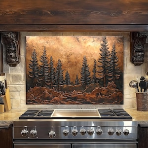 May include: A copper-toned metal wall art piece depicting a forest scene with tall pine trees. The artwork is mounted above a stainless steel gas range in a kitchen setting. The kitchen has dark wood cabinetry and a stone backsplash.