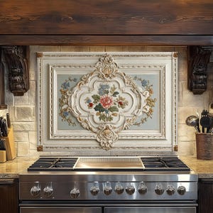 May include: A kitchen with a stainless steel gas range and a decorative floral panel above. The panel is framed in white with ornate detailing and features a central floral arrangement in pink, blue, and green.