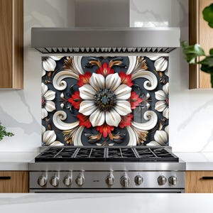 May include: A decorative kitchen backsplash featuring a large floral design. The design includes white, red, and gold flowers with intricate details against a dark gray background. The backsplash is installed above a stainless steel gas range.