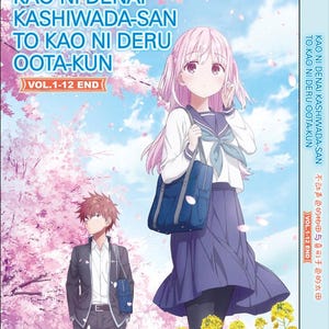 May include: DVD case with anime artwork. The title "KAO NI DENAI KASHIWADA-SAN TO KAO NI DERU OOTA-KUN" is displayed in blue and white text. A girl with pink hair and a school uniform is in the foreground, with a boy in a suit behind her.
