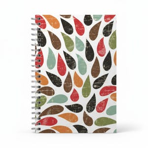 May include: A spiral-bound notebook with a white background and a repeating pattern of teardrop shapes in various colors, including red, orange, brown, green, black, and teal. The teardrops have a distressed, vintage look.