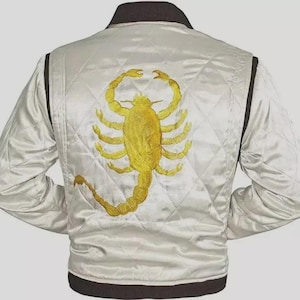 May include: White satin jacket with a gold scorpion embroidered on the back. The jacket has a quilted pattern, black trim, and a black collar. The sleeves are long and the jacket is a classic bomber style.