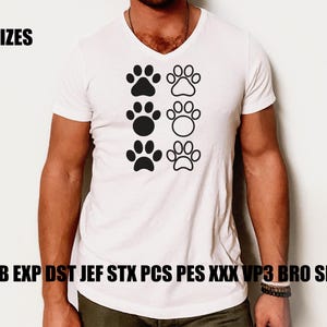 Puede incluir: Camiseta blanca con cuello en V con seis huellas de patas negras. El texto "5 SIZES" está encima de las huellas de las patas, y el texto "EMB EXP DST JEF STX PCS PES XXX VP3 BRO SEW" está debajo.