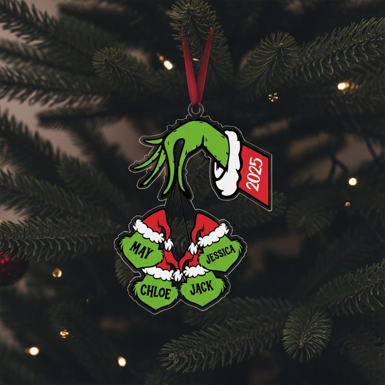 May include: A Christmas ornament featuring a green hand holding a wreath of four green ornaments with names: May, Jessica, Chloe, and Jack. The ornament includes a red tag with the year 2025.