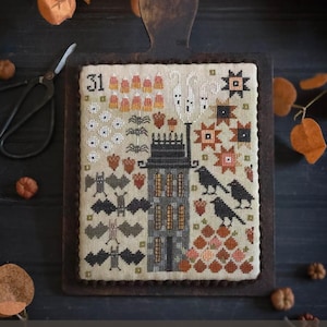 May include: A cross-stitch sampler with a Halloween theme, featuring a spooky house, bats, crows, and pumpkins. The sampler is displayed on a wooden board with the text "Charcuterie Board" and "Plum Street Samplers".