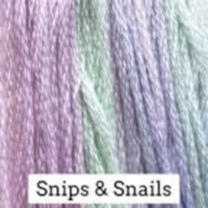 May include: A skein of multi-colored embroidery floss in shades of lavender, purple, green, and white. The floss is labeled "Snips & Snails".