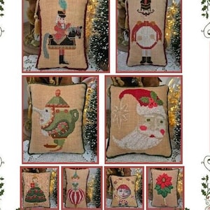 May include: A collection of small, rectangular Christmas-themed pillows. Each pillow features a cross-stitch design of festive characters like a nutcracker, Santa Claus, and a Christmas tree. The pillows are beige with detailed embroidery and decorative trim.