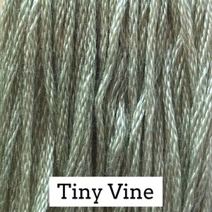 May include: A close-up of a skein of green and white yarn with the text "Tiny Vine" printed on the bottom.