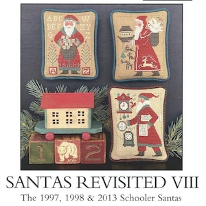 May include: Four cross-stitch patterns featuring Santa Claus in different scenes. The patterns are framed in blue and white fabric. The patterns are titled "Santas Revisited VIII" and "The 1997, 1998 & 2013 Schooler Santas".