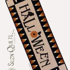 May include: A Halloween themed table runner with a black and white background and orange and brown accents. The runner features the text "Halloween" in a black font. The runner is 17 inches by 47 inches.