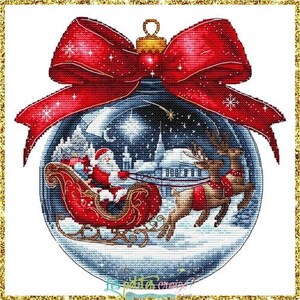 May include: A Christmas ornament with a red bow and a detailed cross-stitch design. The ornament features Santa Claus in a sleigh pulled by reindeer, set against a snowy winter scene. The ornament is round with a gold-colored top.