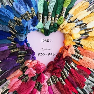May include: A heart-shaped arrangement of colorful DMC embroidery floss skeins. The floss is arranged in a rainbow of colors, including blues, greens, yellows, oranges, reds, pinks, and purples. The text "DMC Colors: 920-996" is in the center.