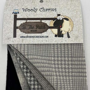 May include: A set of three fabric swatches in a gray and white plaid pattern, a black and white houndstooth pattern, and a solid black fabric. The swatches are labeled "Wooly Charms" and "In The Patch Designs".