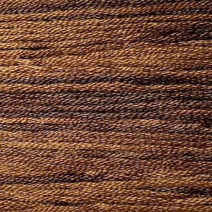 May include: Close-up of a brown and tan textured fabric with a woven pattern. The fabric is made of many thin strands of yarn that are tightly woven together.