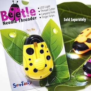 May include: A yellow and black ladybug-shaped needle threader with a light and a thread cutter. The product is labeled "Beetle Needle Threader" and "Try Me".