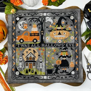 May include: A gray and black cross-stitch sampler with four different Halloween scenes. The scenes include a truck with pumpkins, a witch with a pumpkin, a house with skeletons, and a witch with a broom and a black cat. The text "'Twas All Hallows' Eve" is stitched in the center of the sampler.