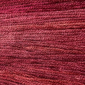 May include: Close-up of a skein of hand-dyed yarn in shades of red and burgundy. The yarn has a textured appearance, with visible strands and subtle color variations. Ideal for knitting, crochet, or other fiber arts projects.