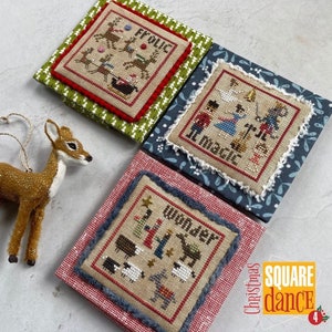 May include: Three framed cross-stitch patterns with a Christmas theme. The patterns are titled "Frolic", "It's Magic", and "Wonder". The frames are decorated with different colors and patterns. The text "Christmas Square Dance 4" is visible in the lower right corner.