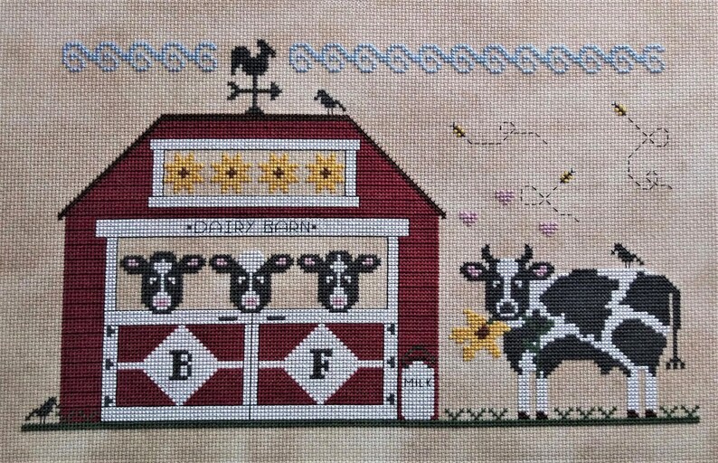May include: A red barn with a white sign that says "Dairy Barn" and four cows inside. A black and white cow with a flower in its mouth stands in front of the barn. There is a milk jug and a weathervane on top of the barn.