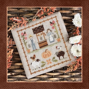 May include: A cross-stitch pattern featuring a farmhouse scene with a well, a pumpkin, a chicken, a sheep, and two figures. The pattern is stitched on a beige fabric with brown, green, and orange accents.