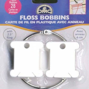 May include: A package of 28 white plastic floss bobbins with a 2.5 inch ring. The package says "Floss Bobbins Carte de Fil en Plastique avec Anneau" and "Easy-wind Facile à embobiner 1 = 1".