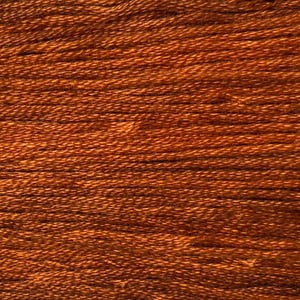 May include: Close-up of a spool of brown embroidery floss. The threads are tightly wound, creating a textured surface. The color is a warm, earthy brown, suitable for various craft projects.