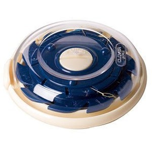 May include: A blue and white plastic thread organizer with a clear lid. The organizer has a circular shape and features a rotating dial with multiple compartments for storing different colors of thread.