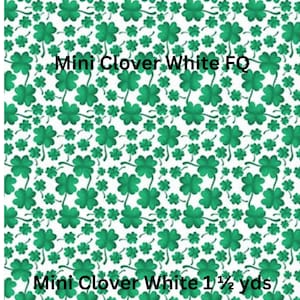 May include: A white fabric featuring a repeating pattern of green four-leaf clovers. The text Lucky Gnomes, Mini Clover White FQ, and Mini Clover White 1 1/2 yds is printed over the clover design in a clear, bold black font.
