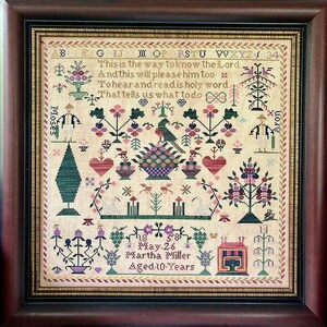 May include: Framed antique cross-stitch sampler with a dark wood frame. The sampler features floral and geometric designs, a bird, and text that reads "This is the way to know the Lord." It also includes the name "Martha Miller" and the date "May 26".